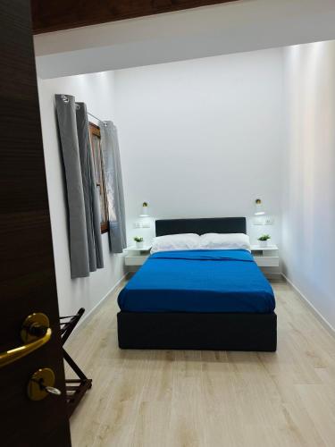 a bed in a white room with a blue mattress at TBS House in Alghero