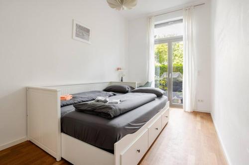 a bedroom with a large bed with a large window at Helenas place in Berlin