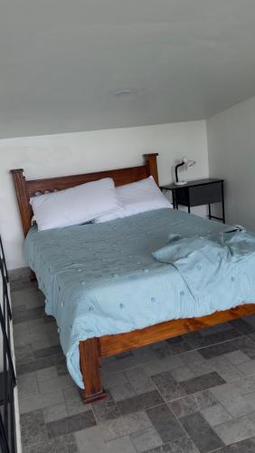 a bedroom with a large bed with a wooden frame at The Jungle Chalet in Cebadilla