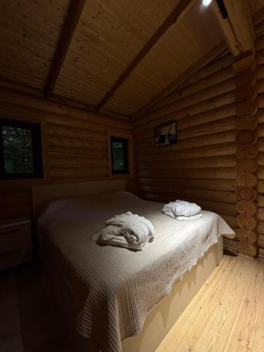 a bed in a wooden room with two towels on it at Buriani-resort in Tsʼkhvarichamia