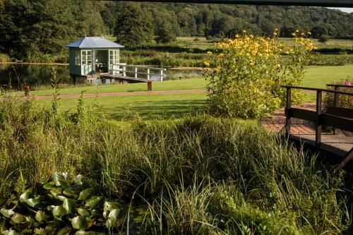 a park with a small house in the middle of a field at Romantik Hotel Waldschlösschen in Schleswig