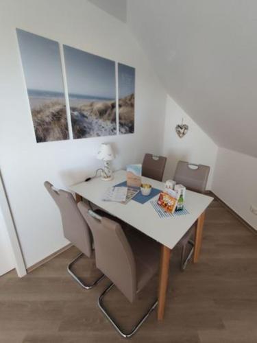 a dining room with a table and chairs and two windows at Ostseebrise in Grömitz