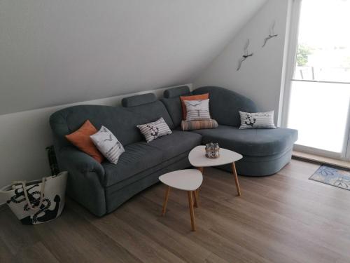 a living room with a blue couch and a table at Ostseebrise in Grömitz