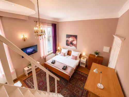 a small room with a bed and a television at Royal Rose Suite in zentraler Lage in Bremen