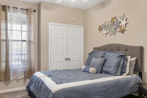 a bedroom with a bed with blue pillows at Mid-City Serenity Oasis in Huntsville