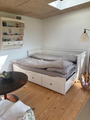 a white bed in a room with a wooden floor at Skuret Maribo in Maribo