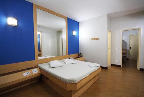 ein Schlafzimmer mit einem Bett und einem großen Spiegel in der Unterkunft Jumbo Hotel in Rio de Janeiro