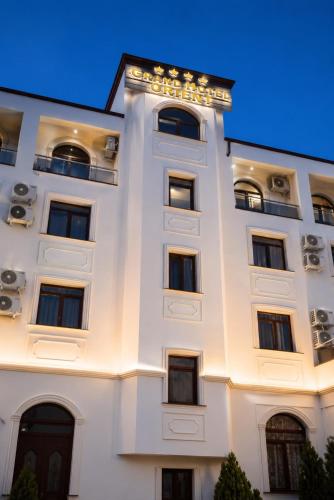 ein weißes Gebäude mit Lichtern in der Unterkunft Grand Hotel Orient Braila in Brăila
