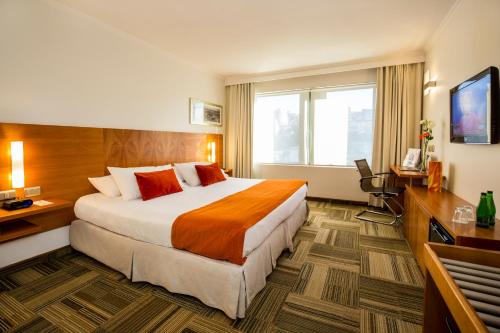 Habitación de hotel con cama grande y TV en Best Western Marina del Rey en Viña del Mar