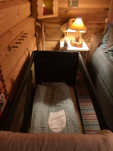 a room with a bed and a table with a lamp at Log cabin in rural surroundings in Stjoerdal