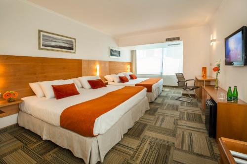 a hotel room with two beds and a television at Best Western Marina del Rey in Viña del Mar