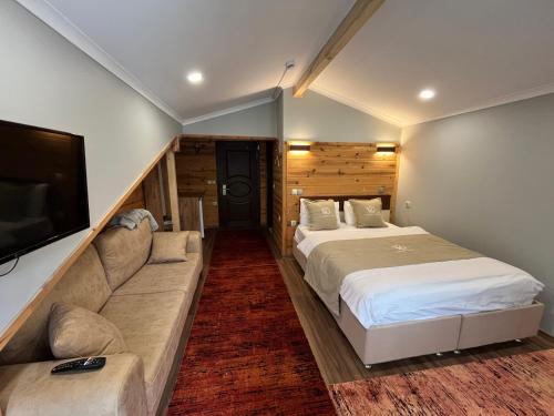 a bedroom with a large bed and a couch at Yedigoller Hotel & Restaurant in Uzungöl