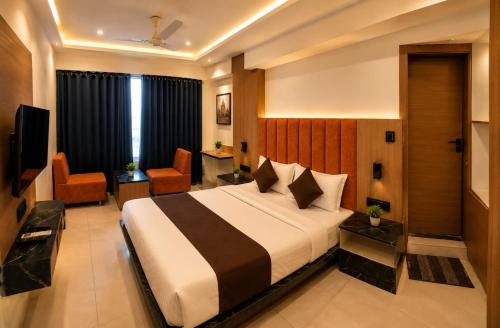 a hotel room with a bed and a television at HOTEL CAMPUS in Ahmedabad