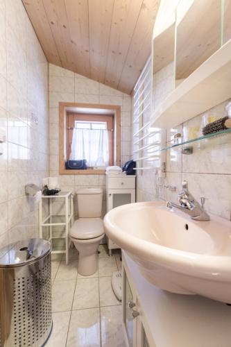 a white bathroom with a sink and a toilet at Hütte Wilfried in Hainzenberg