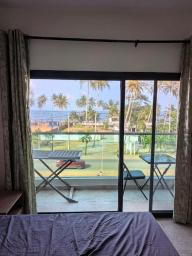 a bedroom with a view of the beach from a window at Résidence Leyla in Abidjan