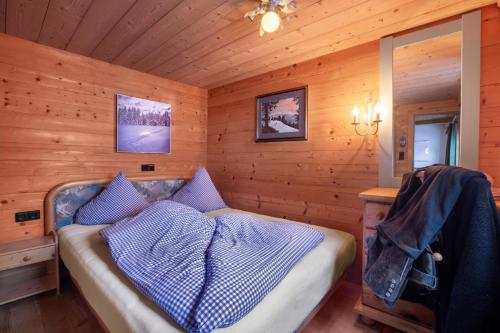 a bedroom with a bed in a wooden cabin at Hütte Wilfried in Hainzenberg