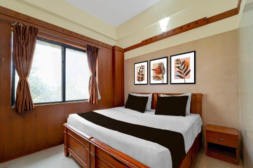a bedroom with a large bed and a window at Hotel O Stay First in Coimbatore