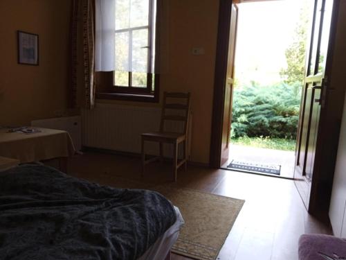 a bedroom with a bed and a sliding glass door at Nimród vendégház in Mőcsény