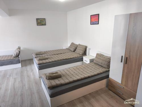 a living room with three beds and a door at Emara Lodge Bansko in Bansko