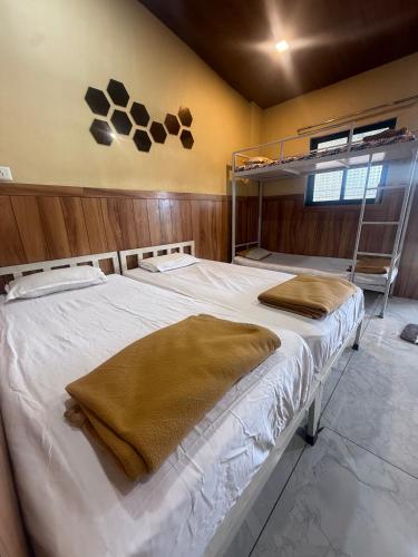 a bedroom with a large bed with white sheets at Green Fog Guesthouse in Lonavala