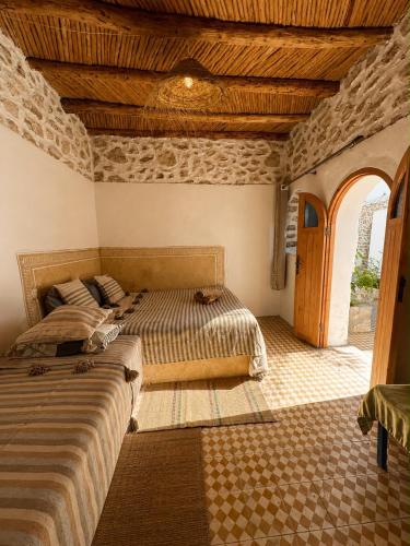 a bedroom with two beds and an arched doorway at SIDI KaouKI PERLA in Sidi Kaouki
