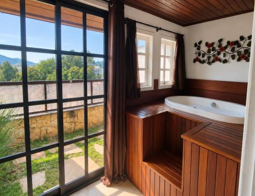 ein Badezimmer mit Badewanne und großem Fenster in der Unterkunft Hotel Willisau in Teresópolis