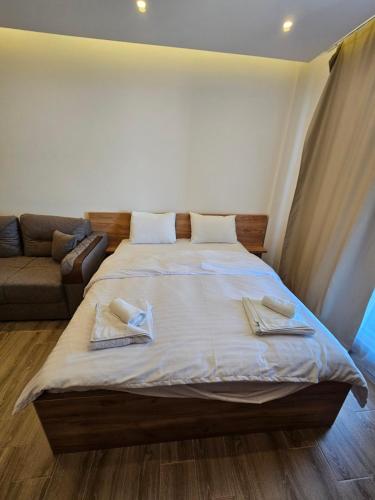 a bedroom with a large bed and a couch at Hill residence A 119 Boby in Cajetina