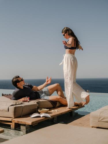 a woman is standing on a raft in the water at Tropicana Suites & Villas Mykonos in Paradise Beach