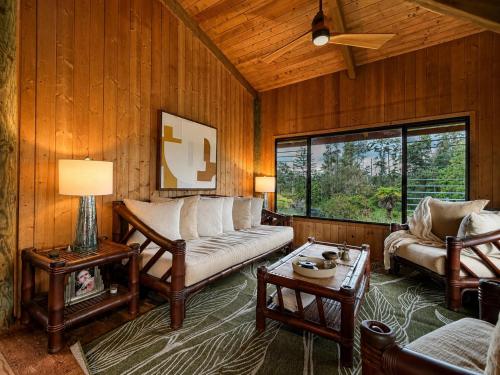 a living room with a couch and a table at Tiki Treehouse in Keaau