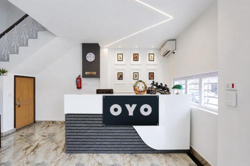 a white lobby with a qo sign on a counter at Hotel O A5 Blue in Gorakhpur