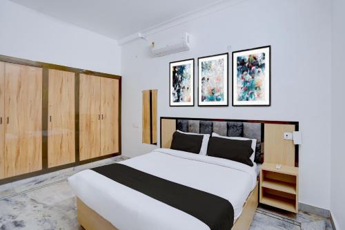 a bedroom with a large white bed and wooden cabinets at Hotel O A5 Blue in Gorakhpur