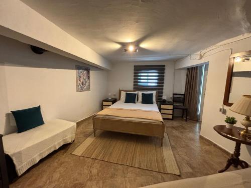 a bedroom with a bed and a couch and a table at Alfeios cozy stays - Rustic 