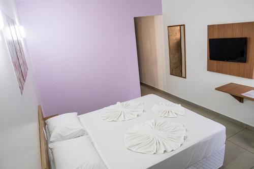 a white room with two white pillows on a bed at Manacá Hotel in Foz do Iguaçu
