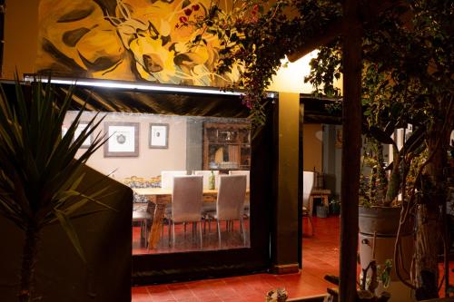 a dining room with a table with white chairs at HOSTEL La Casa de Li - En in Chilecito