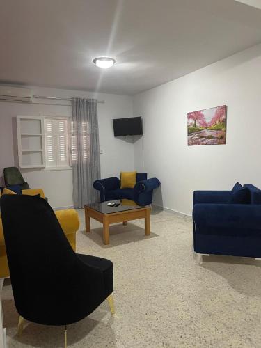 un soggiorno con divani blu e un tavolo di Babylon Gardens a Sousse