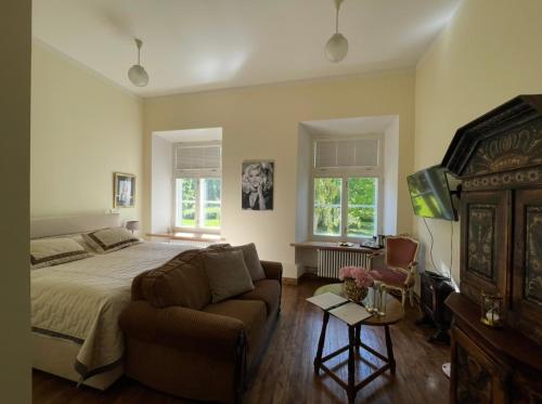 a bedroom with a bed and a couch at Hof Podis Pootsi veinimõis in Pootsi