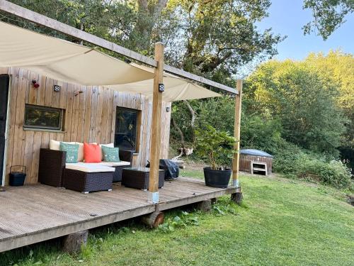 a wooden deck with a couch and a tent at Nesta's Nook in Llandovery