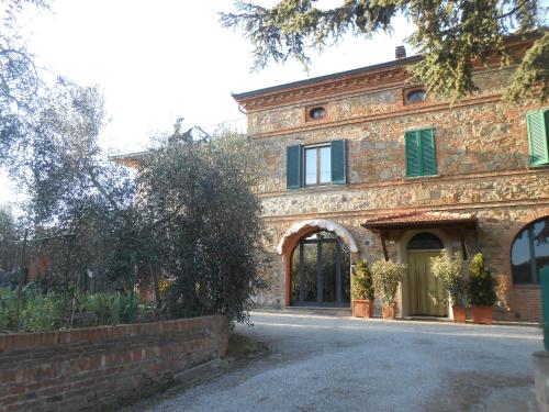 a large brick building with an archway in front of it at Orto degli Ulivi in Sinalunga