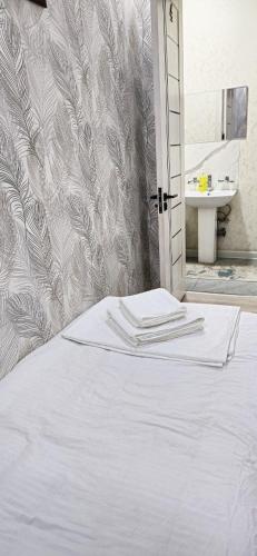 a white bed in a bathroom with a sink at 10 USD New Hotel in Tashkent