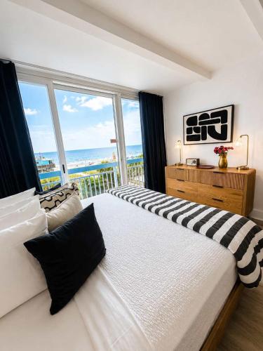 a bedroom with a large bed with a large window at Boardwalk Noir - Oceanfront Studio Yachtsman 404 in Myrtle Beach