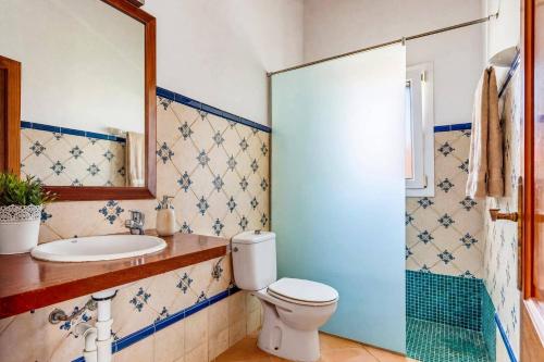 a bathroom with a toilet and a sink at Villa Ingrid Porter by Villa Plus in Cala en Porter