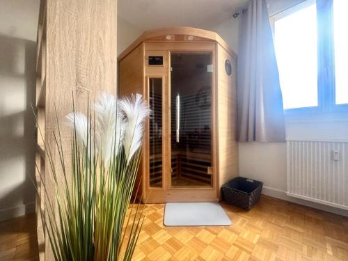 a bathroom with a shower and a plant in a room at Le petit sauna de Sarah in Voiron