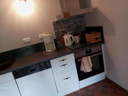a kitchen with white cabinets and a counter top at Ferienwohnung Otto in Kleinich