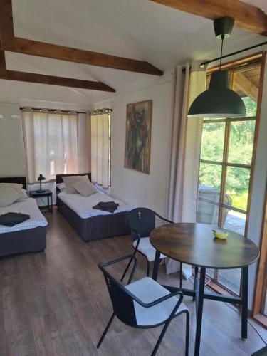 a living room with a bed and a table at dom & weranda in Szczęsne