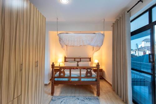 a bedroom with a bed and a window at Diani Luxe villa 1bdr B, 600m from the beach in Galu
