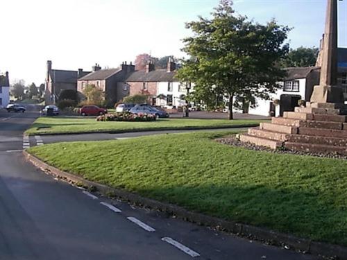 a street with a grass median in a residential neighborhood at The Boot and Shoe in Greystoke