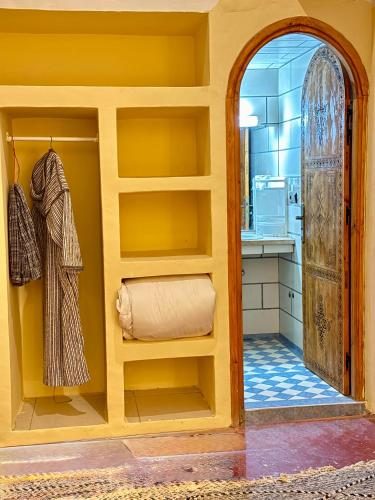 a kitchen with yellow walls and an arched doorway at Dar Zagora Oasis - Authentic Moroccan Stay in Zagora