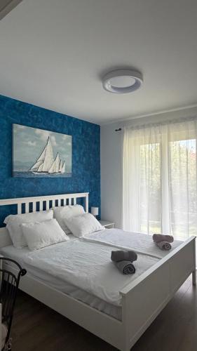 a bedroom with a large bed with a blue wall at Villa Paula Jakišnica with heated pool in Lun