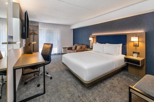 a hotel room with a large white bed and a desk at Comfort Inn in North Bay