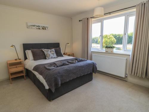a bedroom with a bed and a large window at Bayview Cottage in Bournemouth